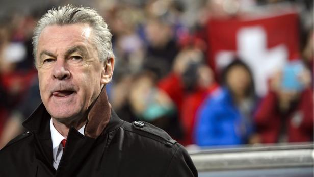 Ottmar Hitzfeld während eines Fussballspiels mit Schweizer Fans im Hintergrund.