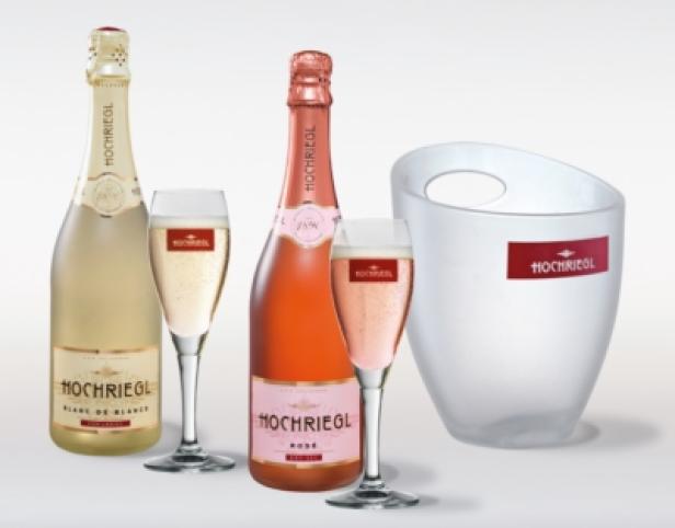 Zwei Flaschen Hochriegl Sekt, ein Weißer und ein Rosé, mit Gläsern und einem Sektkühler.