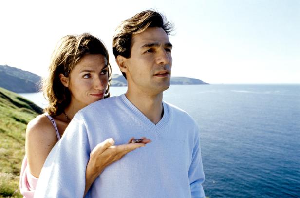 Ein Paar steht an einer Küste mit Blick auf das Meer.