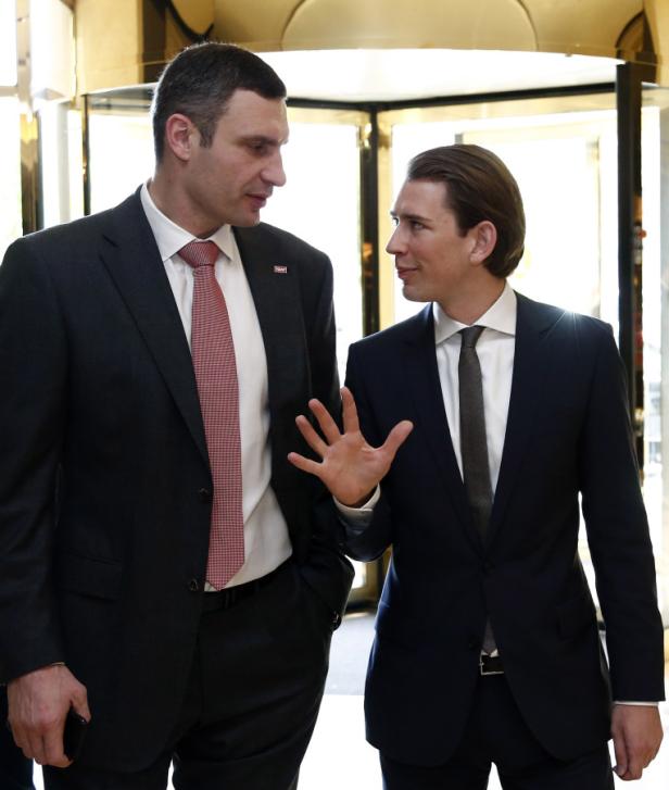 Vitali Klitschko und Sebastian Kurz unterhalten sich vor einem Drehtüreingang.
