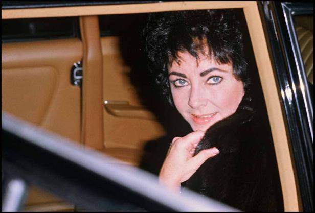 Elizabeth Taylor schaut aus dem Fenster eines Autos.