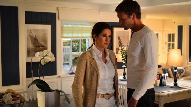 Eine Frau und ein Mann stehen in einem hellen Raum mit maritimer Dekoration.