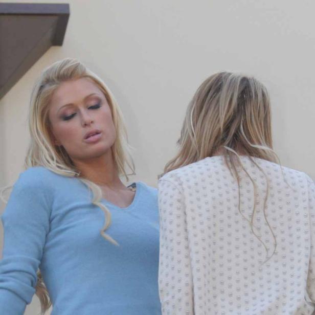 Paris Hilton mit einer anderen Frau, beide blond, vor einer hellen Wand.