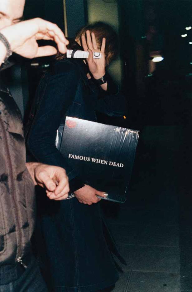 Eine Person hält eine Schallplatte mit dem Titel „Famous When Dead“ vor ihr Gesicht.