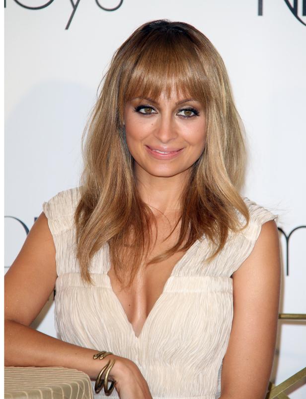 Nicole Richie lächelt in einem elfenbeinfarbenen Kleid.