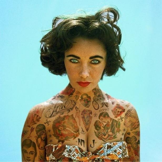 Elizabeth Taylor mit zahlreichen Tätowierungen auf Oberkörper und Armen vor blauem Hintergrund.