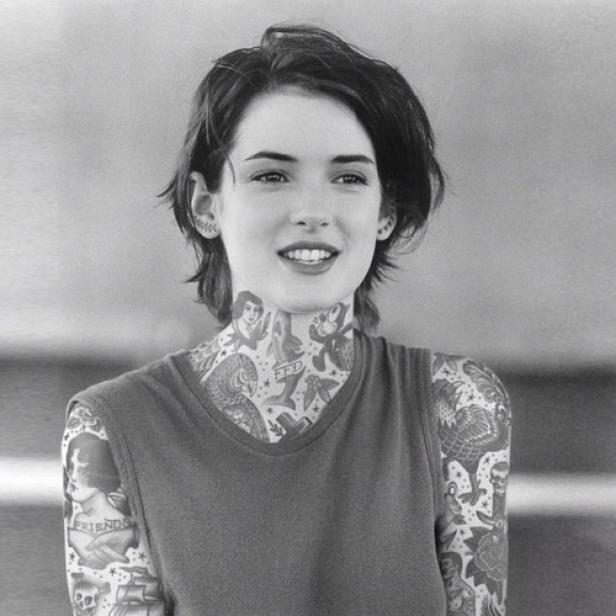 Winona Ryder mit Tätowierungen an Hals und Armen in einem Schwarzweißfoto.