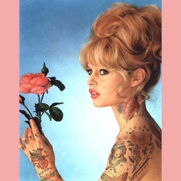 Eine Frau mit blonden Haaren und Tätowierungen hält eine rosa Rose.