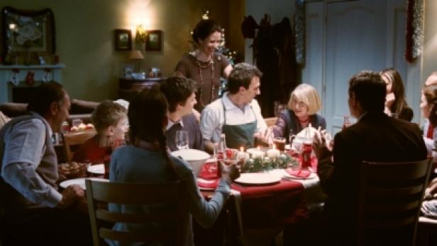 Eine Familie sitzt an einem festlich gedeckten Tisch zum Weihnachtsessen.