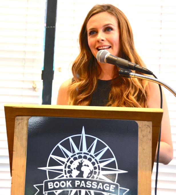 Eine Frau spricht auf einer Veranstaltung am Rednerpult von „Book Passage“.