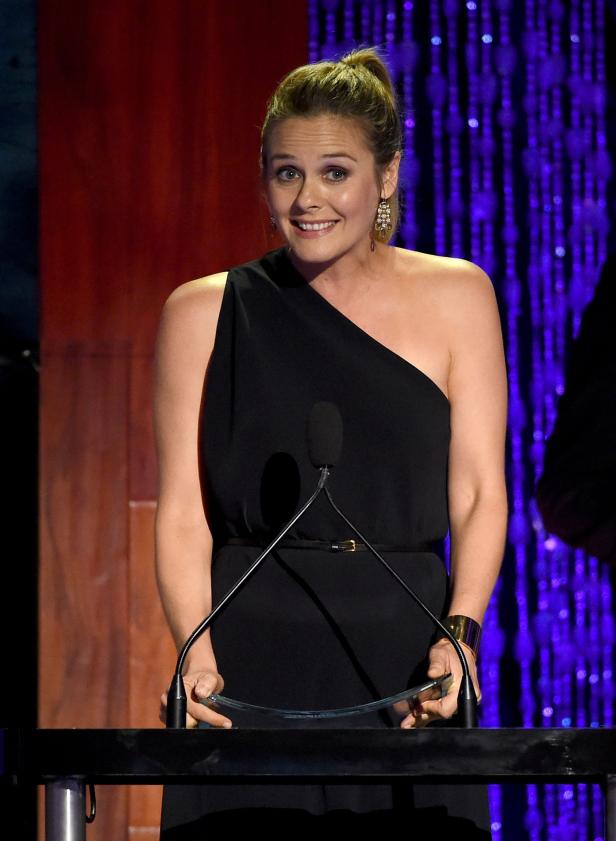 Alicia Silverstone bei einer Preisverleihung am Rednerpult.