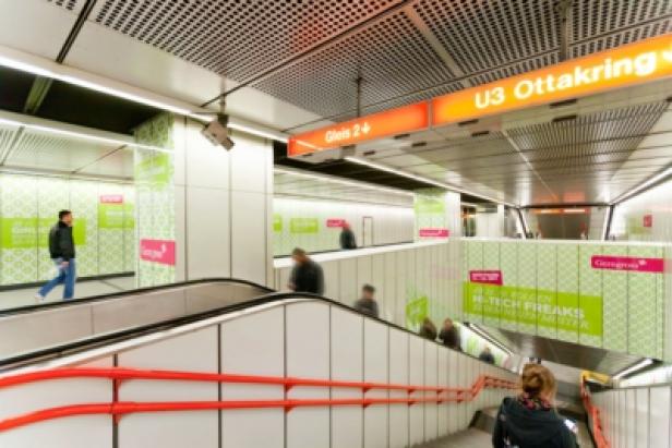 Blick in die U-Bahnstation Ottakring mit Fahrgästen und Hinweisschildern.