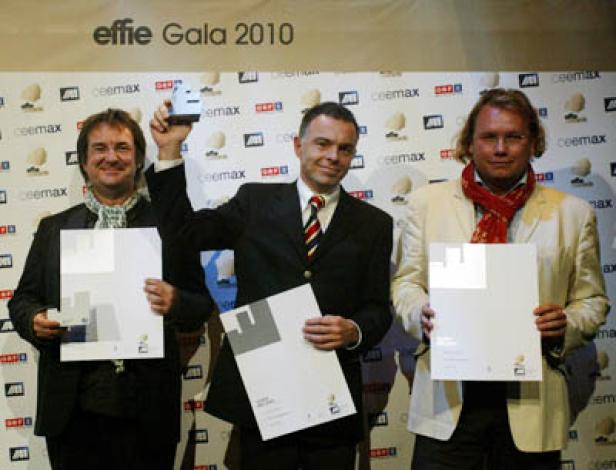 Drei Männer posieren mit Urkunden und einer Trophäe bei der Effie Gala 2010.