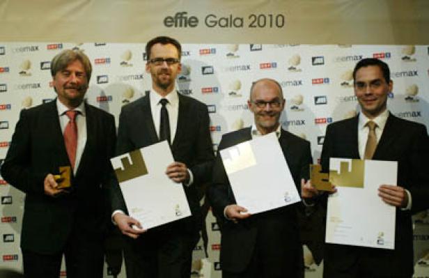 Vier Männer in Anzügen posieren mit Preisen bei der Effie Gala 2010.
