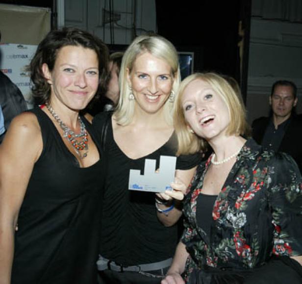 Drei Frauen posieren mit einer Auszeichnung für ein Foto.