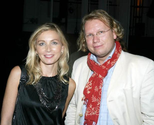Eine blonde Frau und ein Mann mit rotem Schal posieren für ein Foto.