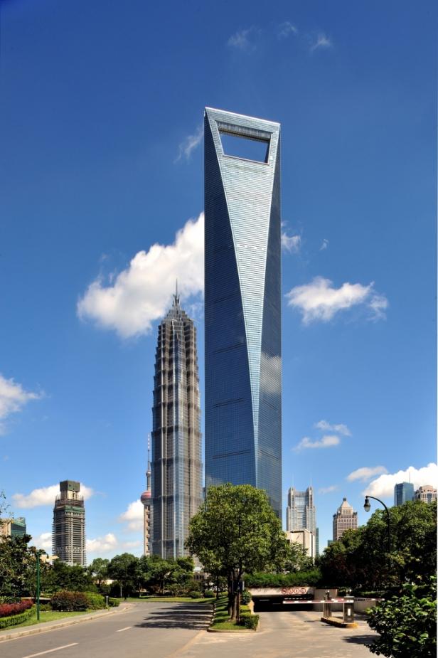 Der Shanghai World Financial Center und andere Wolkenkratzer unter blauem Himmel.