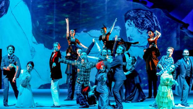 Eine Gruppe von Darstellern mit Totenkopf-Make-up auf einer Bühne.