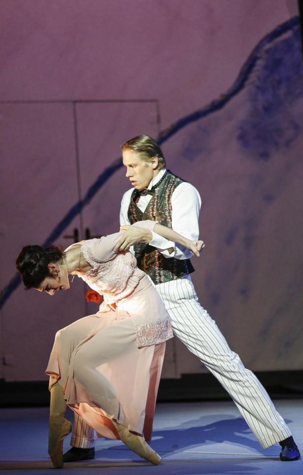 Ein Tänzerpaar führt eine dramatische Szene auf einer Bühne auf.