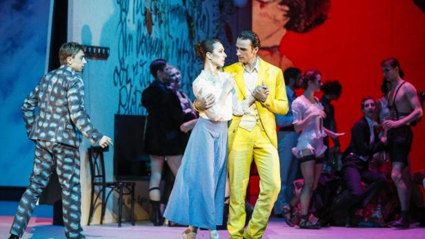 Eine Ballettaufführung mit Tänzern in farbenfrohen Kostümen auf einer Bühne.