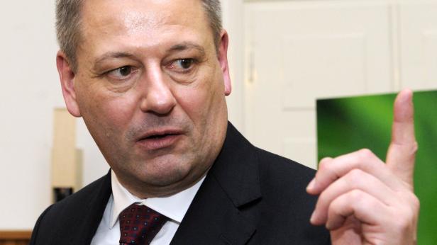 Ein Mann im Anzug hebt warnend den Zeigefinger.