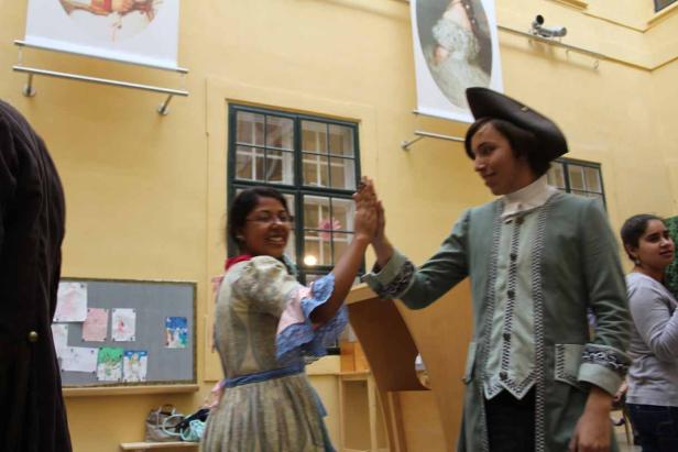 Zwei Personen in historischen Kostümen geben sich ein High-Five.