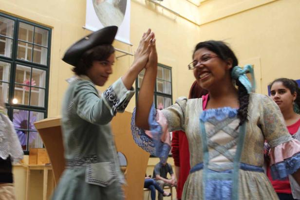 Zwei Personen in historischen Kostümen geben sich ein High-Five.