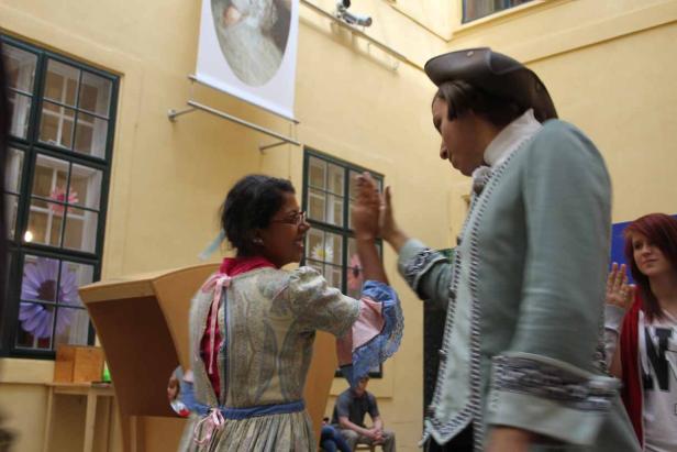 Zwei Personen in historischen Kostümen geben sich ein High-Five.