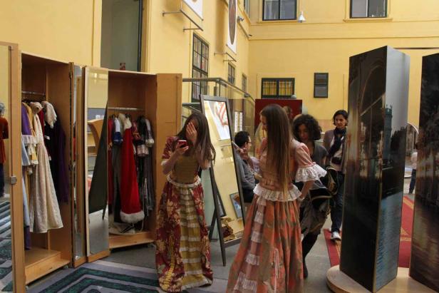Zwei Frauen in historischen Kostümen posieren für Fotos in einem Museum.