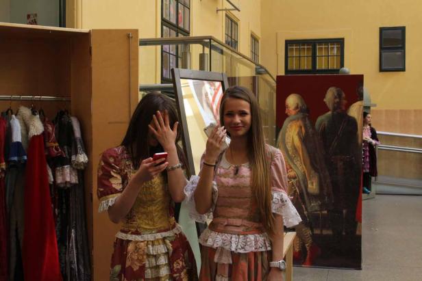 Zwei junge Frauen in historischen Kostümen posieren für ein Foto.