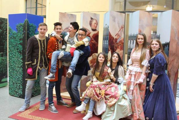 Eine Gruppe junger Leute posiert in historischen Kostümen für ein Foto.