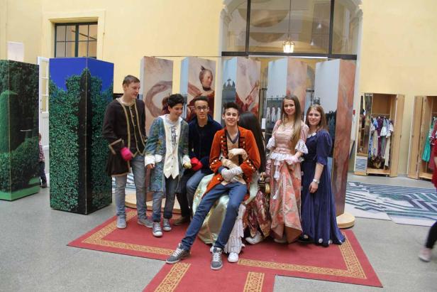 Eine Gruppe junger Leute posiert in historischen Kostümen für ein Foto.