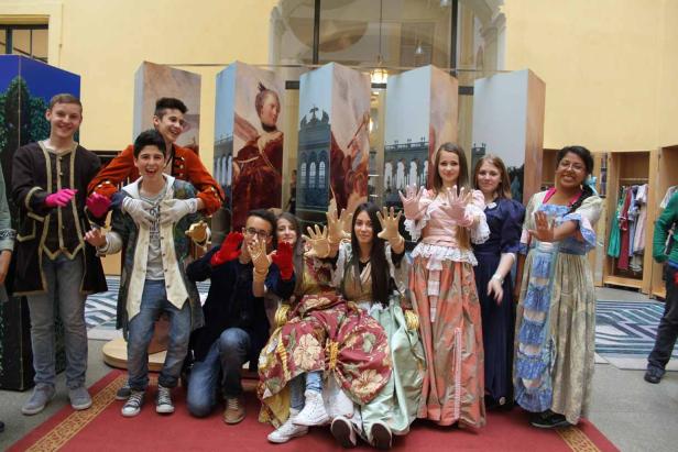 Eine Gruppe von Jugendlichen in historischen Kostümen posiert für ein Foto.