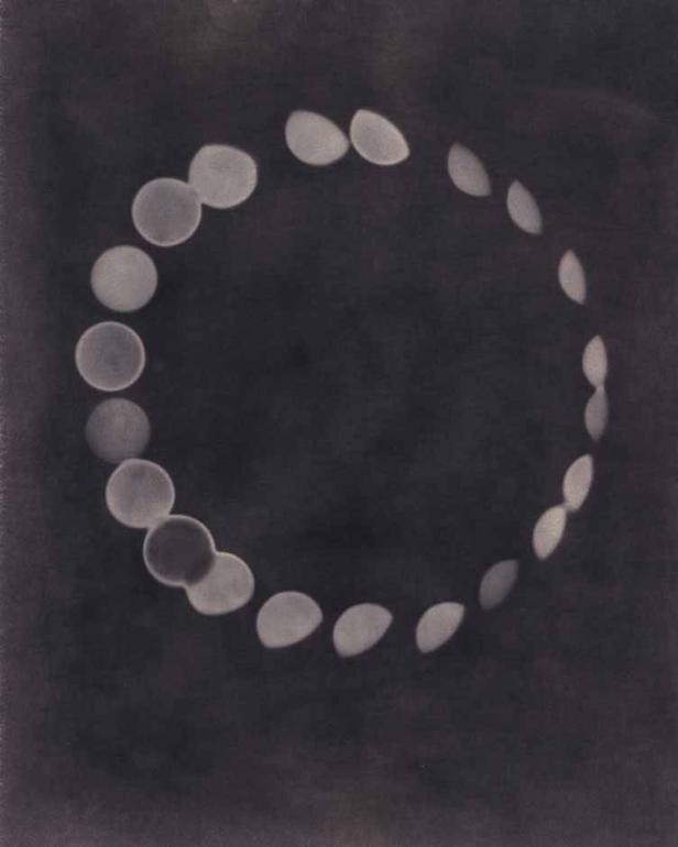 Eine Reihe von hellen, kreisförmigen Formen bildet einen Ring auf dunklem Hintergrund.