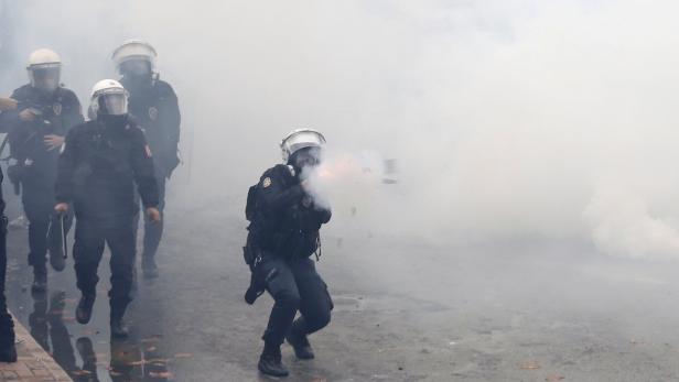 Polizisten in Schutzkleidung inmitten von Rauch bei einem Einsatz.