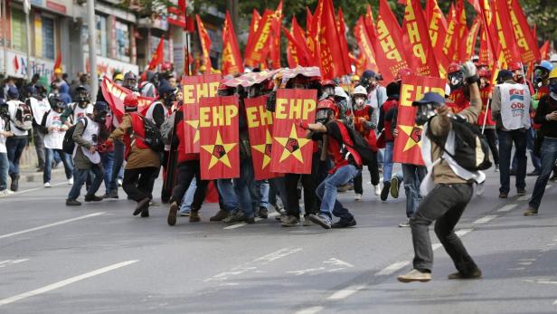 Eine Demonstration mit Menschen, die rote Fahnen und Schilder mit der Aufschrift „EHP“ tragen.