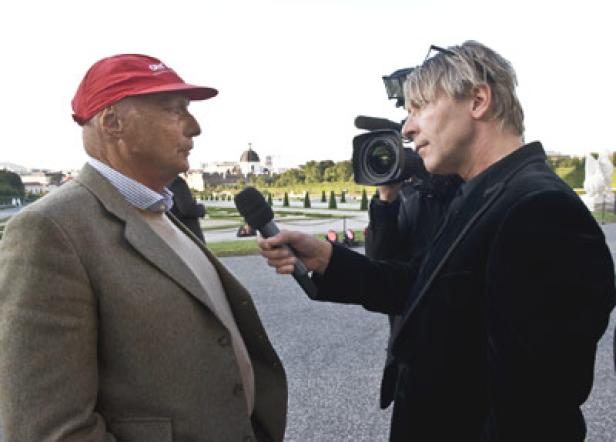 Niki Lauda wird von einem Reporter interviewt; im Hintergrund Schloss Schönbrunn.