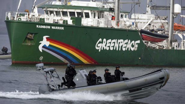 Ein Boot der DSI fährt vor dem Greenpeace-Schiff „Rainbow Warrior“.