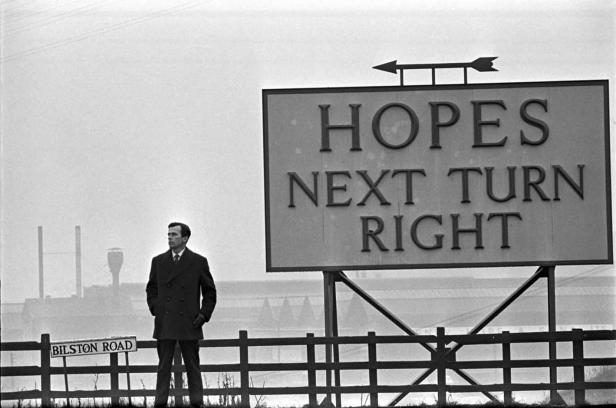 Ein Mann steht neben einem Schild mit der Aufschrift „Hopes Next Turn Right“ an der Bilston Road.
