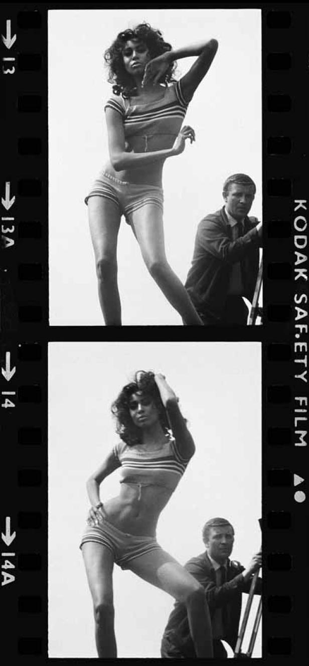 Schwarzweißaufnahme einer Frau in Shorts und eines Mannes mit einer Filmkamera.