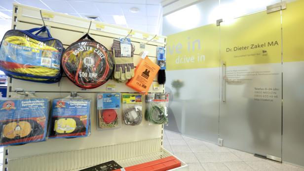 Regale mit Abschleppseilen, Starthilfekabeln, Arbeitshandschuhen und anderem Autozubehör in einem Geschäft.