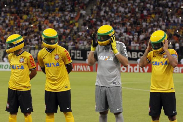 Spieler des SC Corinthians - aus Sennas Geburtsstadt Sao Paulo - ließen sich eine besondere Aktion einfallen und liefen mit Helmen ein Vier Fußballspieler des Corinthians São Paulo tragen gelbe Helme mit Visieren auf dem Spielfeld.