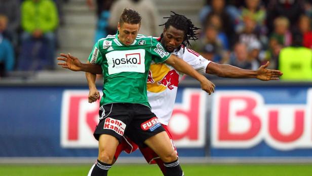 Zwei Fußballspieler kämpfen um den Ball während eines Spiels.