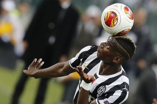 Ein Fußballspieler balanciert einen Ball auf seinem Kopf.