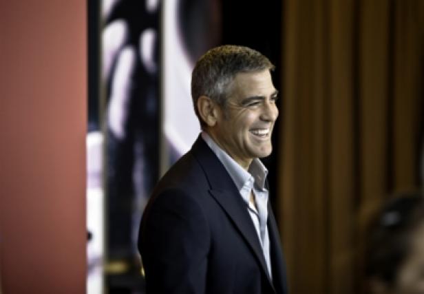 Nespresso/Episode 5/Making of/Mailand/George Clooney (c: nespresso) George Clooney lächelt in einem dunklen Anzug.