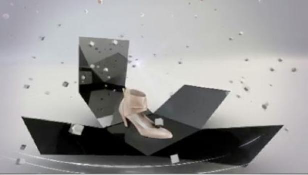 Ein beiger Damenschuh steht in einer geöffneten, schwarzen Box.