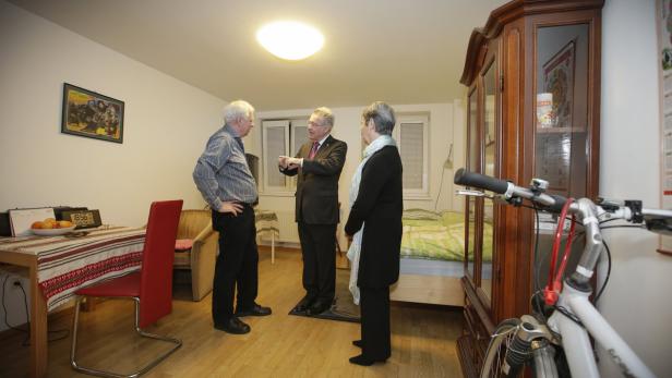 Bundespräsident a. D. Heinz Fischer im Gespräch mit zwei Personen in einem Wohnraum.