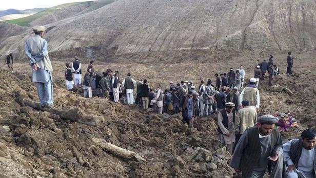 Eine Gruppe von Männern steht auf einem Hügel in einer ländlichen Gegend.