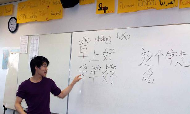 Ein Lehrer erklärt chinesische Schriftzeichen an einer Tafel.