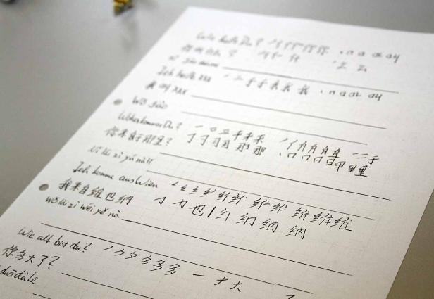 Ein Blatt Papier mit handschriftlichen Notizen auf Deutsch und Chinesisch.